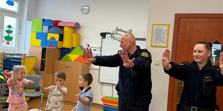 Powiększ grafikę: Dzieci, pracownicy Straży Miejskiej i pies Marley na sali gimnastycznej podczas zajęć edukacyjnych