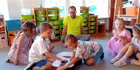 Powiększ grafikę: Dzieci oglądają gitarę pod czujnym okiem taty Franka