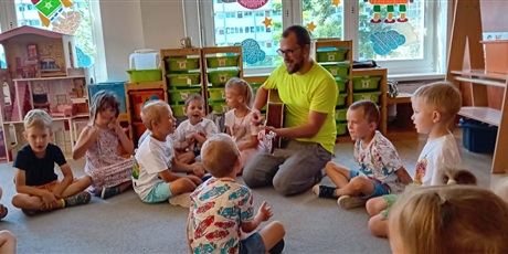 Powiększ grafikę: Na zdjęciu dzieci z grupy III i tata Franka grający na gitarze
