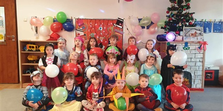 Powiększ grafikę: Dzieci z grupy II pozują do zdjęcia na balu karnawałowym w pięknych strojach. W rączkach trzymają kolorowe balony.